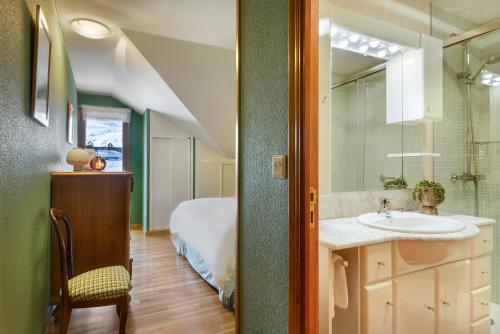 福米加尔Montesqui Formigal, exclusivo ático con vistas a pistas, guardaesquis y garaje的一间带水槽的浴室和一张位于客房内的床