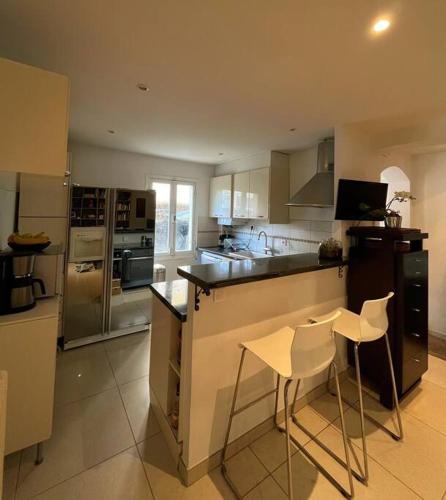 - une cuisine avec un comptoir et 2 chaises dans l'établissement Provencal house, sea side, private parking, à Nice