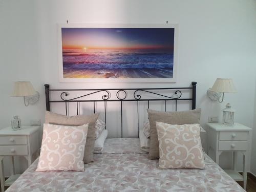 a bedroom with a bed with a picture on the wall at Guest house al mare in Civitavecchia