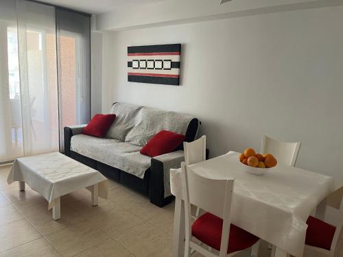Apartamento Canet d’en Berenguer في كانيت ذي بيرينغير: غرفة معيشة مع أريكة وطاولة