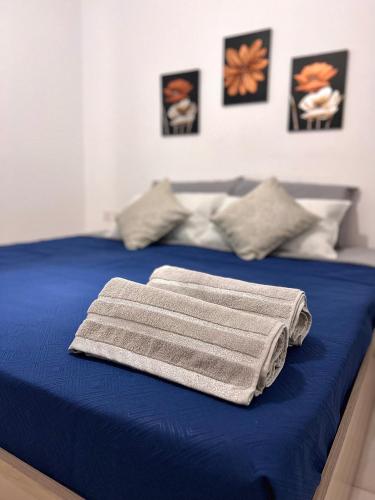 - un lit bleu avec une serviette dans l'établissement Habitación Doble o sencilla en apartamento Compartido en Gzira Malta , zona centrica, à Il-Gżira