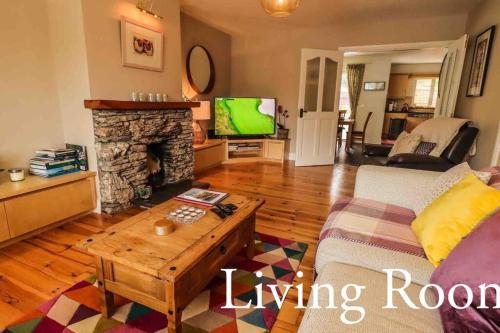 a living room with a couch and a fireplace at Skelligway Kenmare - Your Luxury Holiday Home in Kenmare