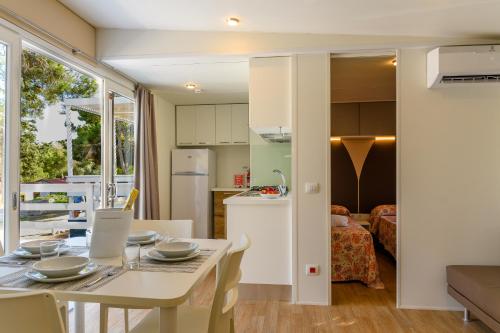 a kitchen and living room with a table and chairs at Camping La Scogliera in Santa Cesarea Terme