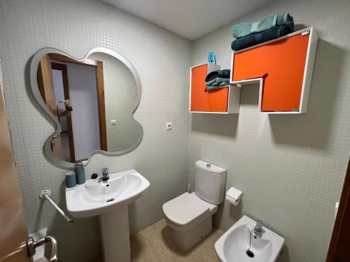 W łazience znajduje się umywalka, toaleta i lustro. w obiekcie Apartamento Canet d’en Berenguer w mieście Canet de Berenguer