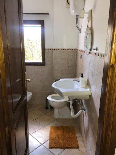 a bathroom with a sink and a toilet and a window at La casa di Giulio in Maccarese