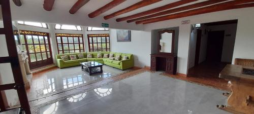 a living room with a green couch and a table at Hotel Bosque de la Villa in Villa de Leyva