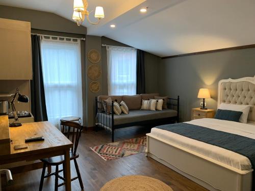 a bedroom with a bed and a couch and a table at Loka Suites in Istanbul