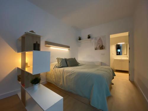 een witte slaapkamer met een bed en een tafel bij La Marquesa in Murcia