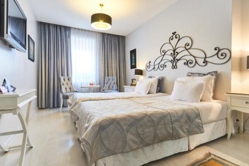 a hotel room with two beds and a desk at Celal Sultan Hotel Special Class in Istanbul