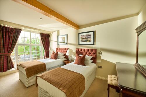a hotel room with two beds and a window at Ulbster Arms Hotel near Thurso in Halkirk