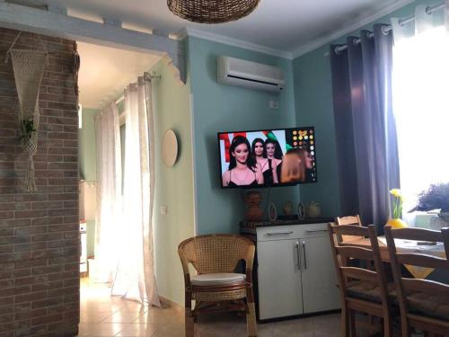 a living room with a tv on a blue wall at Pandora's Seaview Apartment in Durrës