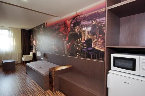 una camera d'albergo con letto e forno a microonde di Corvin Apartman a Gyula
