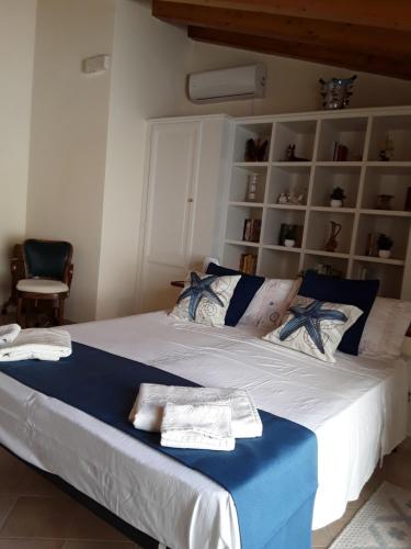 Schlafzimmer mit einem großen Bett mit blauer und weißer Bettwäsche in der Unterkunft Sweet Dream House in Carloforte