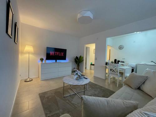 a living room with a white couch and a tv at Stilvolle 52qm Wohnung in attraktiver Lage in Essen
