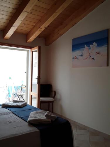 a bedroom with a bed and a large window at Sweet Dream House in Carloforte