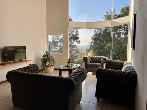 una sala de estar con 2 sofás y una ventana grande en Herradura VIP Inn, en Mazamitla
