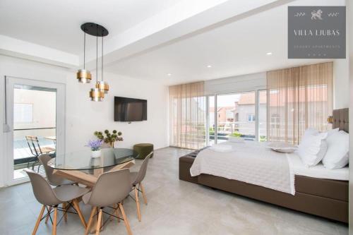 a bedroom with a bed and a table and a dining room at VILLA LJUBAS in Srima