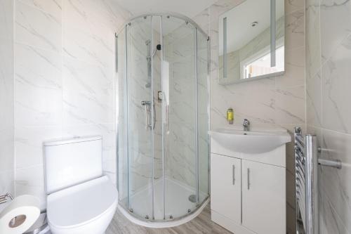 a bathroom with a shower and a toilet and a sink at Charming Hotel with Kitchen & Laundry near Tufnell Park in London