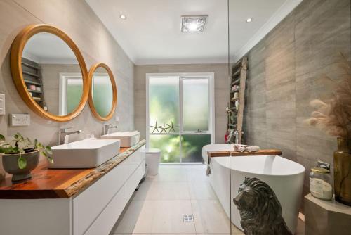 baño con 2 lavabos y espejo grande en Delamarele, en Medlow Bath