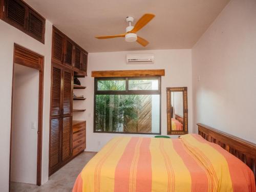 a bedroom with a bed and a ceiling fan at Casa Pelicano in Puerto Escondido