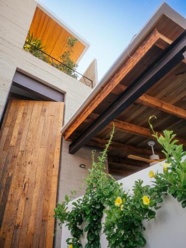 a house with wooden ceilings and potted plants at Casa Pelicano in Puerto Escondido
