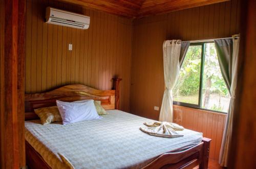a small bedroom with a bed with a window at Hospedaje y alojamiento Cabañas Don Beto in La Palma