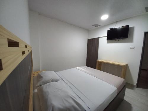 a bedroom with a bed and a flat screen tv at Hotel 42 Avenida in Palmira