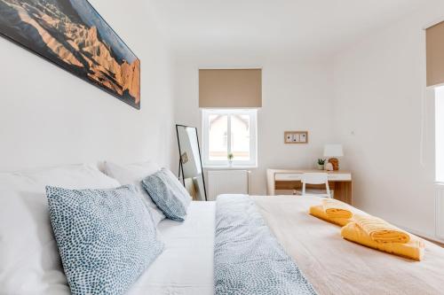 a white bedroom with a bed with two towels on it at Modern, bright and spacious apartment in Prague
