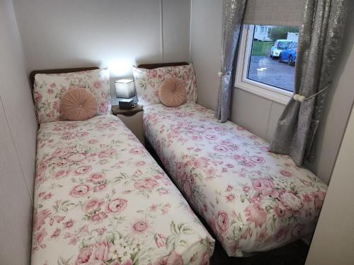 two beds in a small room with a window at Rosie's Seton Retreat in Port Seton