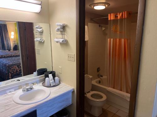 Un baño con lavabo, inodoro y ducha. en Lebanon Inn Motel, en Lebanon