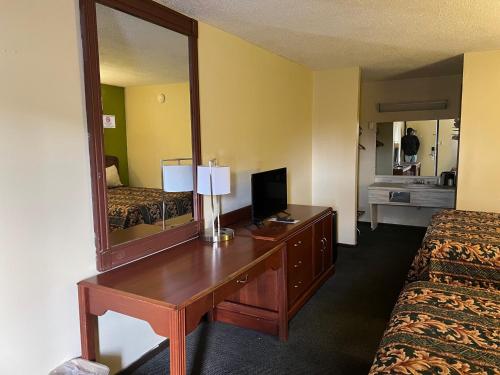 a hotel room with a desk and a mirror at Lebanon Inn Motel in Lebanon