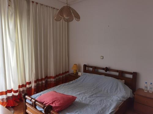 a bedroom with a bed with a red pillow at Silence area 1 in north Athens in Akharnaí