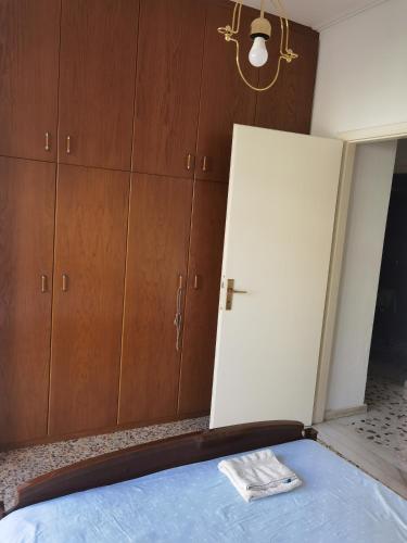 a room with a bed and wooden cabinets at Silence area 1 in north Athens in Akharnaí