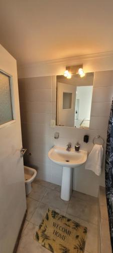 uma casa de banho com um lavatório, um espelho e um WC. em Departamento monoambiente Barrio Martin em Rosário
