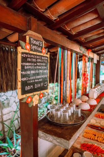 a food stand with a sign and a menu at Pousada Barbara in Pipa