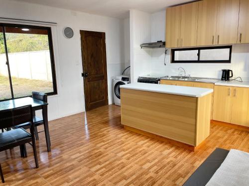 a kitchen with a counter and a table in a room at Cabañas Los Naranjos - Lanco in Lanco