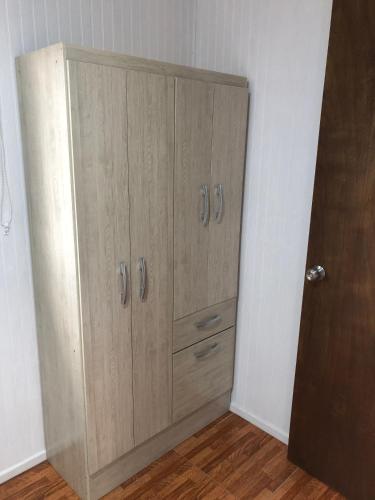 a large wooden cabinet in a corner of a room at Cabañas Los Naranjos - Lanco in Lanco