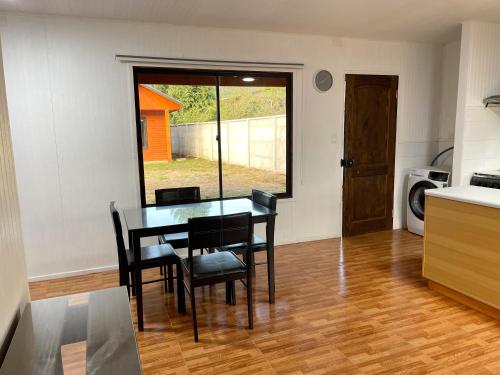 a dining room with a table and chairs in a kitchen at Cabañas Los Naranjos - Lanco in Lanco