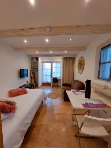 une chambre avec un grand lit et un salon dans l'établissement Logement d'exception près du Colorado provencal dans une résidence au calme avec piscine offrant une vue imprenable sur le Luberon depuis sa terrasse, à Viens