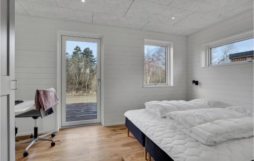 een slaapkamer met 4 bedden, een bureau en een raam bij Nice Home In Sams With Kitchen in Ballen