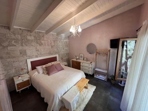 a bedroom with a bed and a table and a window at El Shaddai Casa de Montaña in Lago Puelo