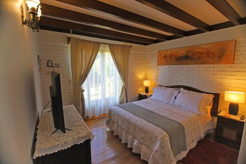 1 dormitorio con 1 cama y TV en Casa Emiluz en La Serena