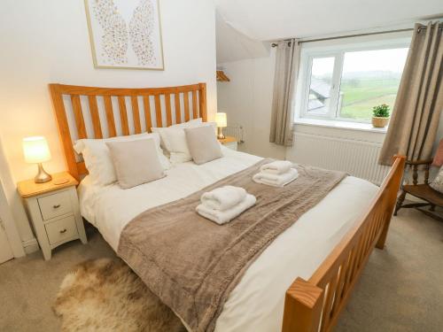 a bedroom with a large bed with towels on it at 3 Moorview in Buxton