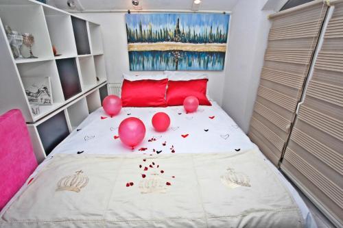 a bedroom with pink balloons on a bed at Art apartman in Kakanj