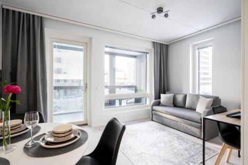 a living room with a couch and a table at Apartment near the train station, free parking &Netflix in Kuopio