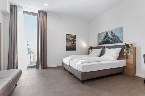 um quarto com 2 camas e um sofá em Flatista Homes - Aubing em Munique