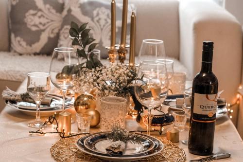 a table with a bottle of wine and glasses on it at Art apartman in Kakanj