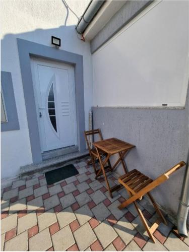 une paire de chaises et une table devant une porte dans l'établissement White pearl, à Sukošan