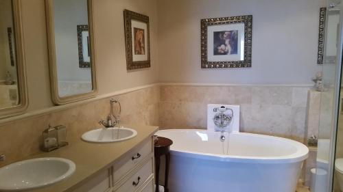 a bathroom with two sinks and a large tub at Mt Bijoux Preferred Accommodation in Bloubergstrand