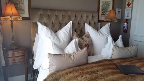 a bed with a bunch of pillows on it at Mt Bijoux Preferred Accommodation in Bloubergstrand